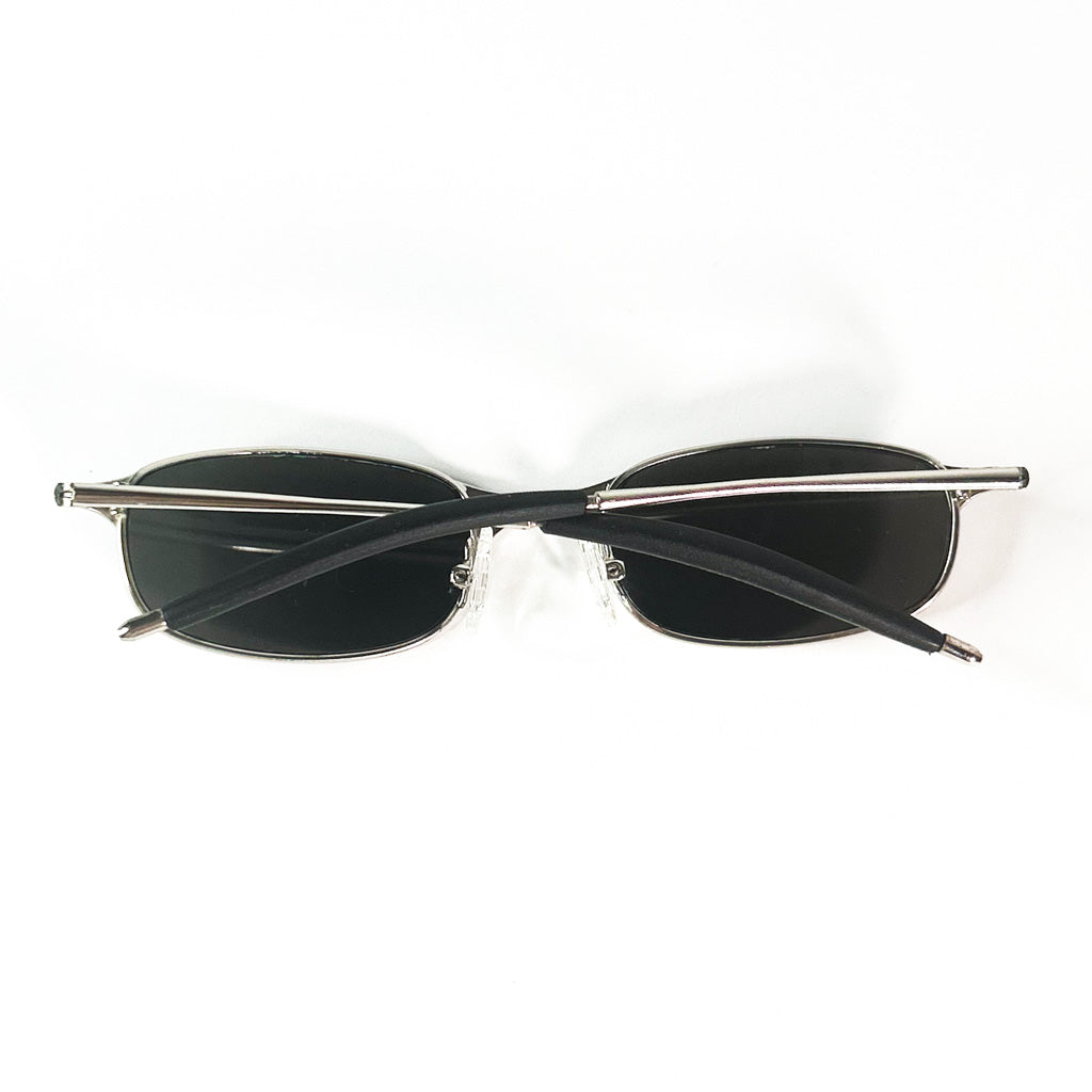 Branches croisées de lunettes de soleil rectangulaires avec monture métallique et verres noirs