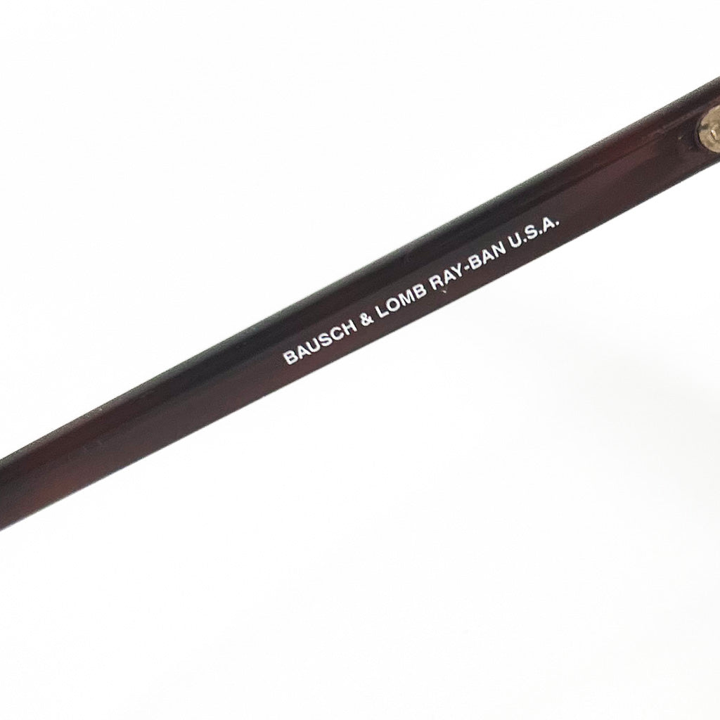 Gros plan sur l’inscription ‘BAUSCH & LOMB RAY-BAN U.S.A.’ gravée sur la branche écaillée d’une monture Clubmaster