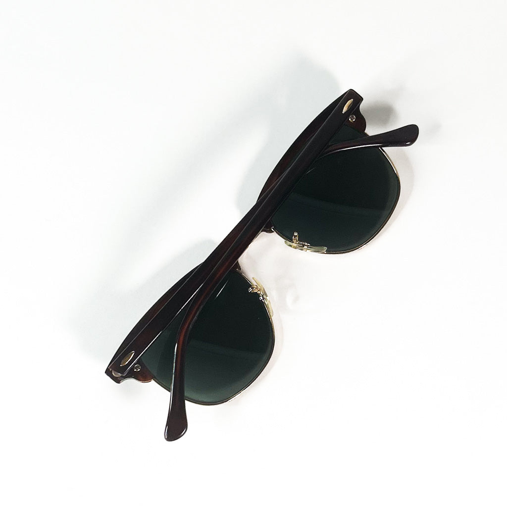 Vue de dessus d’une paire de lunettes Ray-Ban Clubmaster USA pliées, branches croisées sur fond blanc