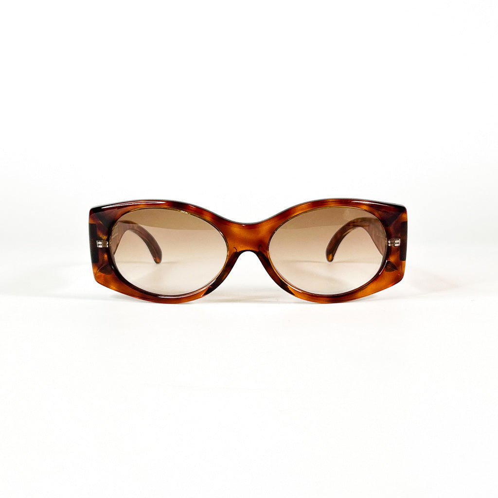 vue de face d’une paire de lunettes solaires vintage écaille avec verres dégradés bruns sur fond blanc