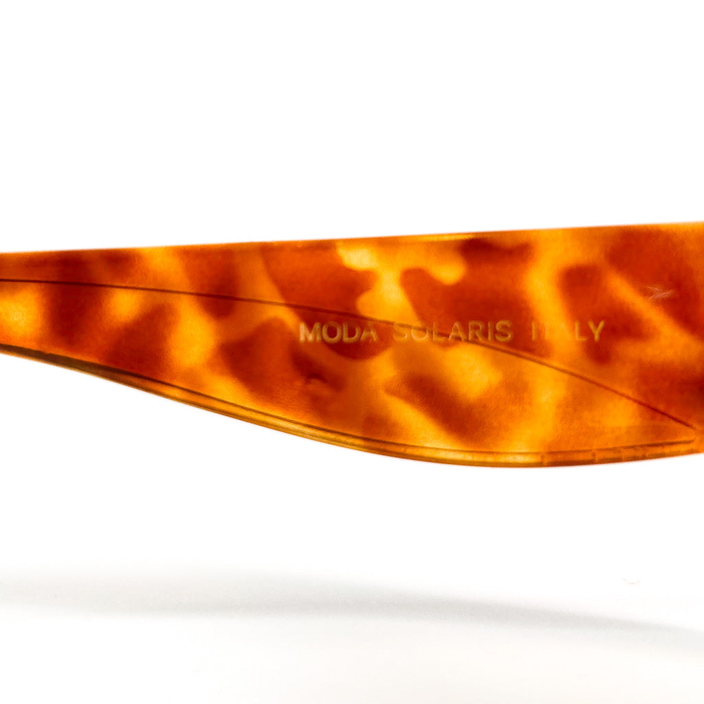 gros plan sur la gravure 'MODA SOLARIS ITALY' sur la branche écaille des lunettes