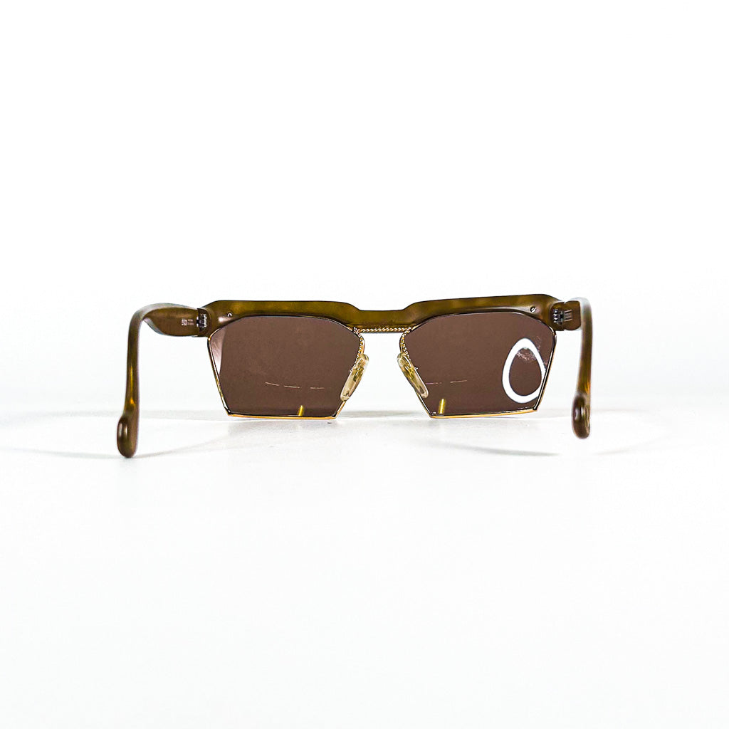 Vue en plongée des lunettes de soleil vintage Christian Lacroix 7318 avec branches repliées et monture en optyl brun translucide