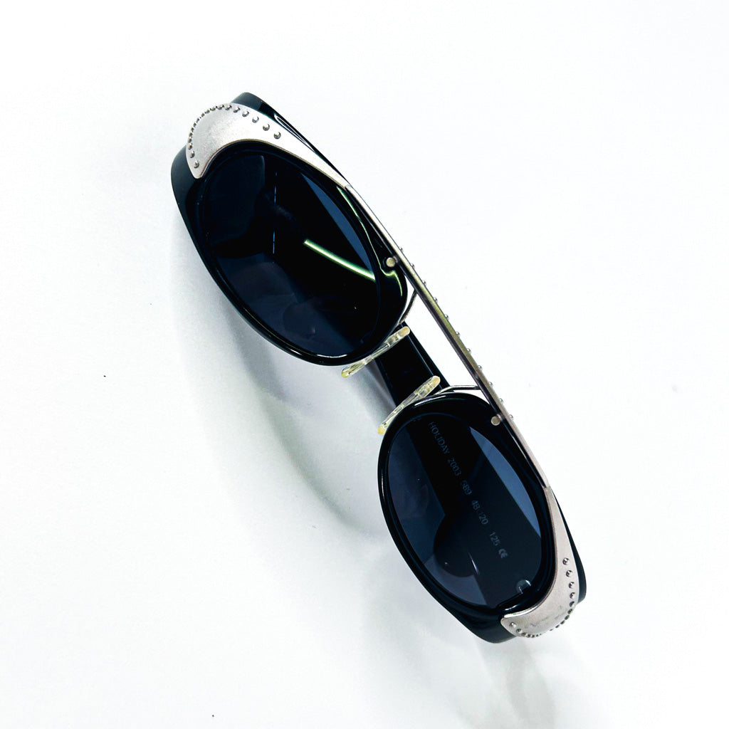 Vue de trois-quarts des lunettes Neostyle Holiday 2003 noir brillant avec inserts métalliques rivetés