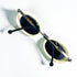 Lunettes de soleil ovales Courrèges ivoire posées à plat vue de trois quarts
