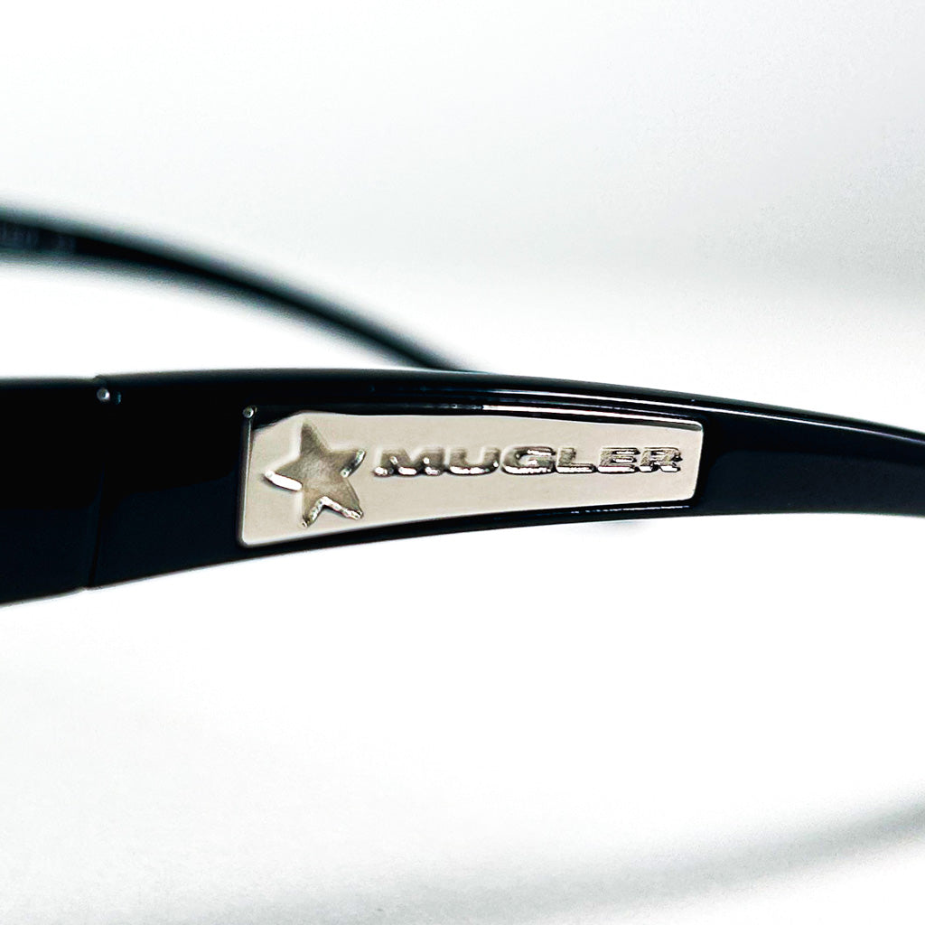 Logo Mugler gravé sur plaque métallique étoile - détail de la branche