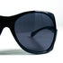 Zoom sur les verres fumés et la monture noire oversize des lunettes Mugler