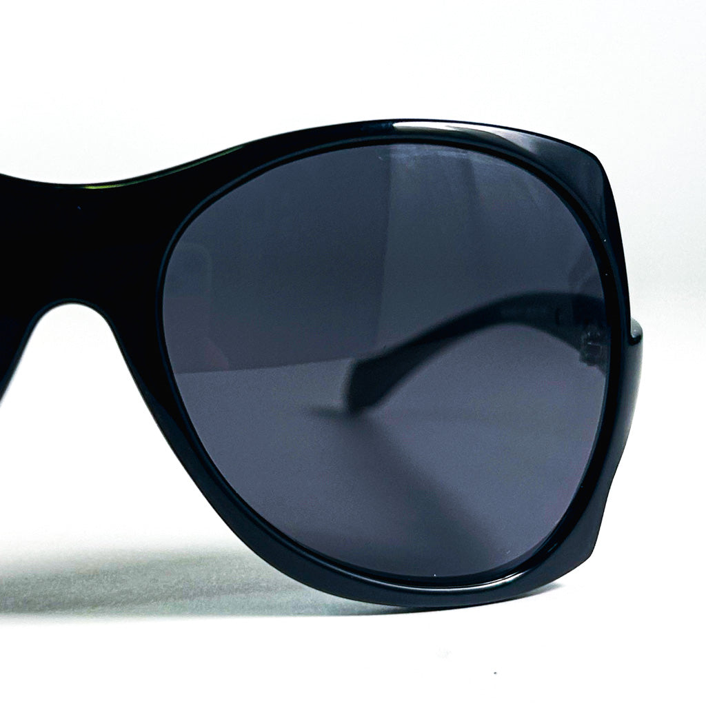 Zoom sur les verres fumés et la monture noire oversize des lunettes Mugler