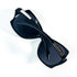 Lunettes de soleil Mugler TM10183 C1 pliées, vue en plongée sur les branches croisées et le logo étoile