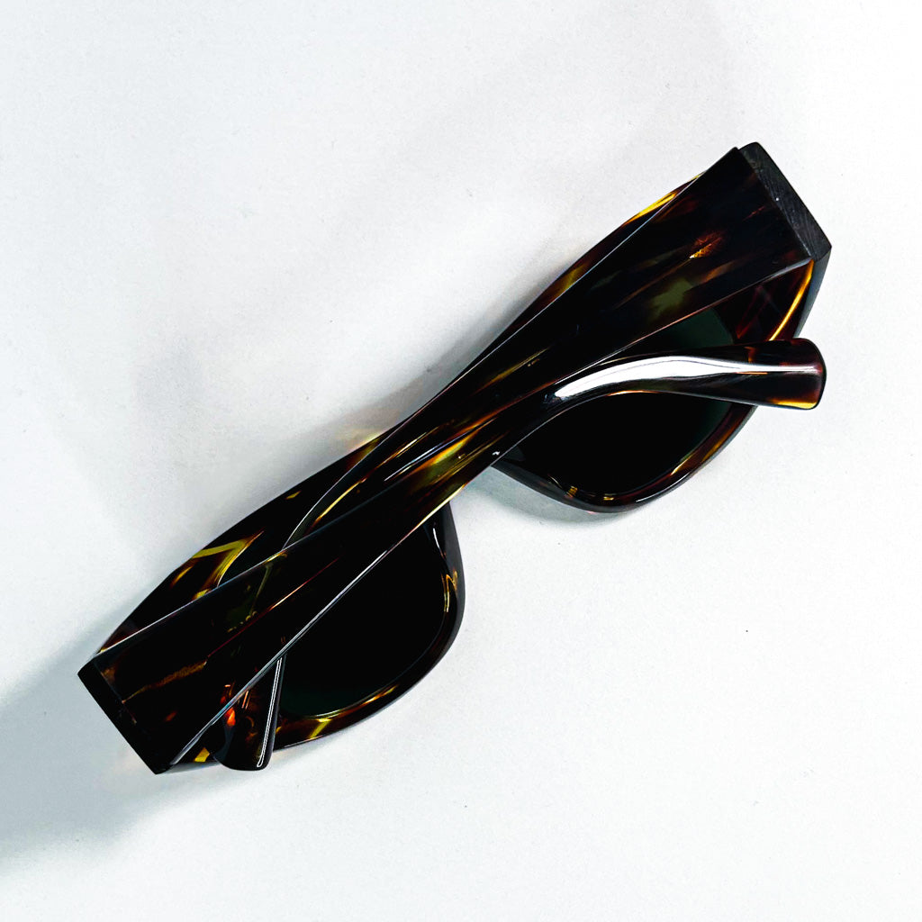 Lunettes Ansolet Alain Mikli x Vauthier repliées - branches croisées sur fond blanc