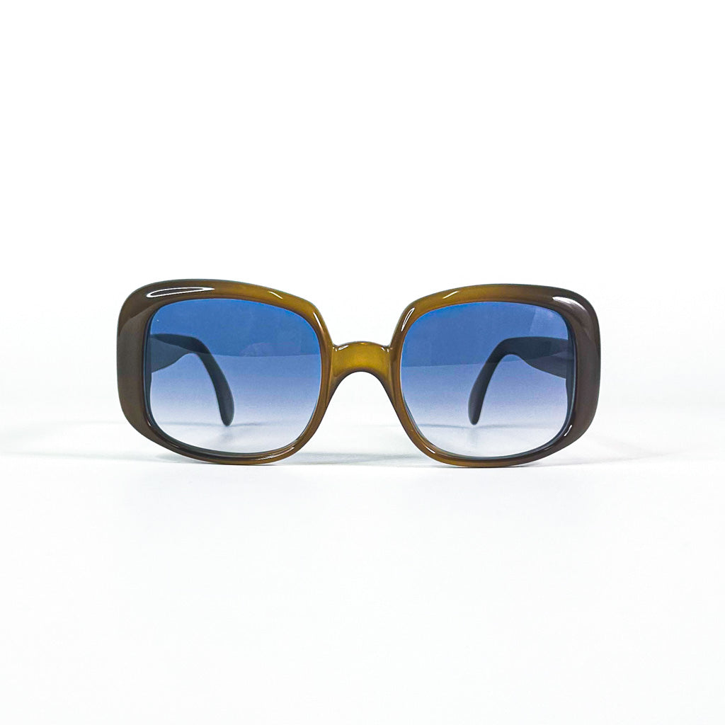 Vue de trois quarts des lunettes de soleil Christian Dior en acétate marron et branches larges avec verres bleus dégradés