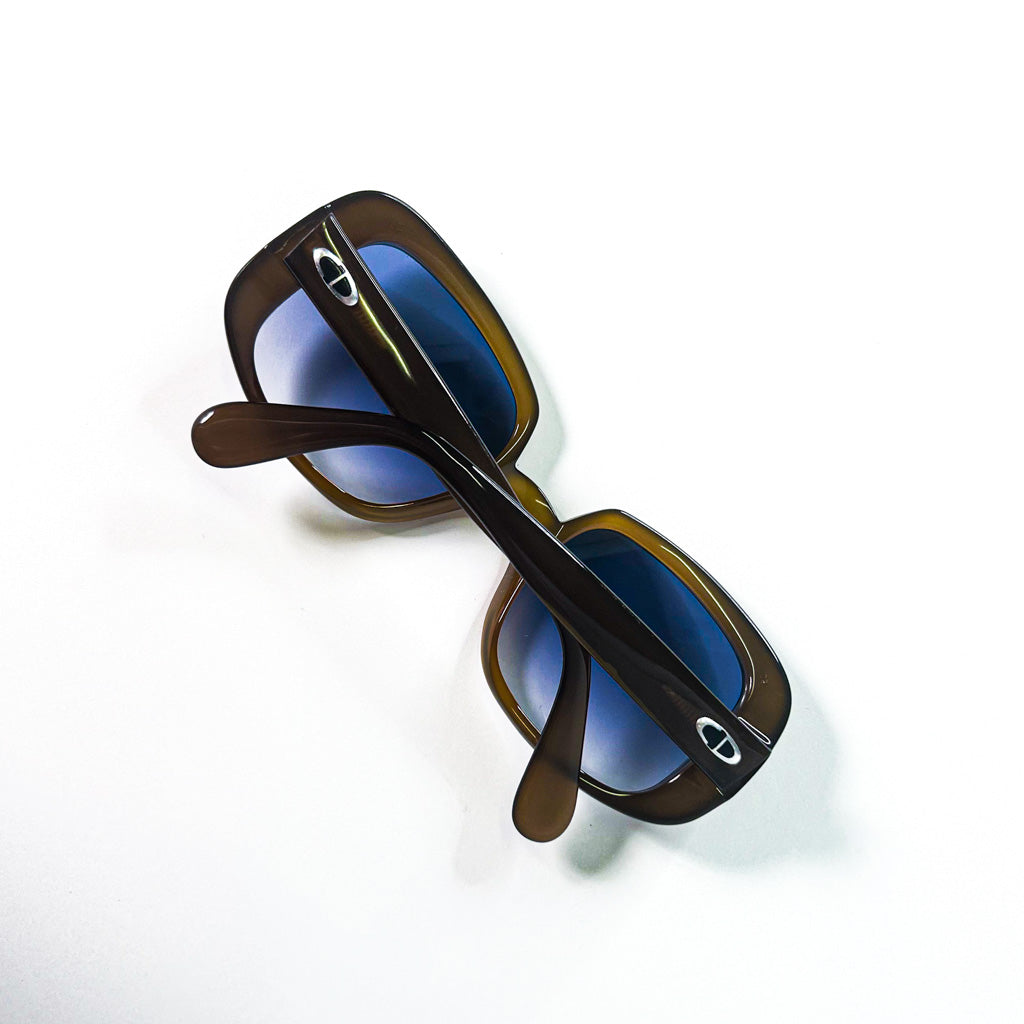 Variante de la vue plongeante des lunettes pliées, centrée sur les branches et les détails du logo
