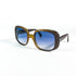 Vue de trois quarts des lunettes de soleil Dior posées à plat, soulignant la brillance de l’acétate et la teinte bleue des verres