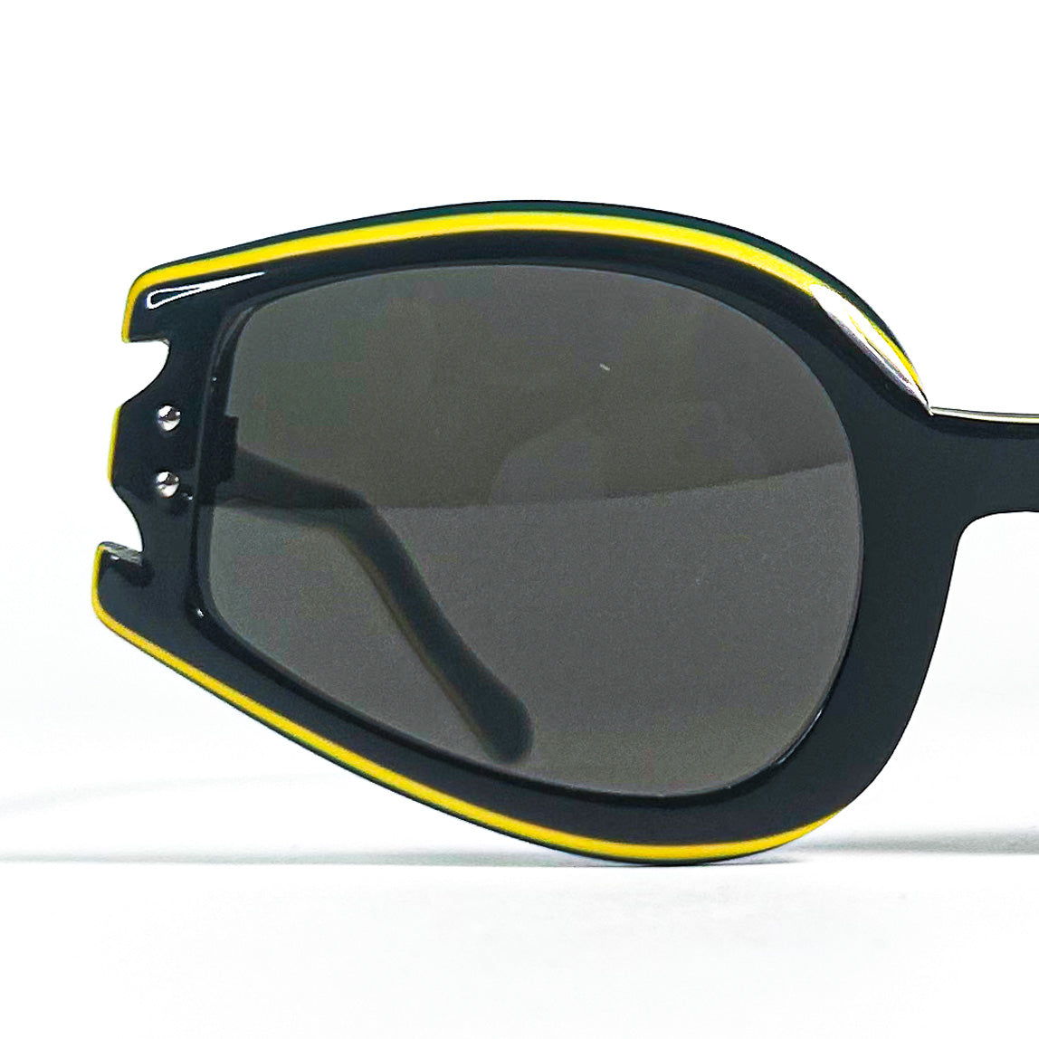 Lunettes de soleil vintage noires et jaunes – gros plan sur le contour du verre et les détails sculptés