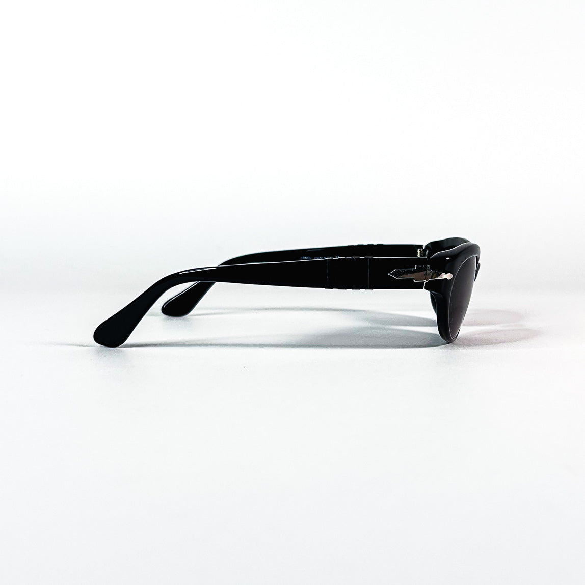 Lunettes Persol noires posées vues de côté montrant la silhouette allongée des branches