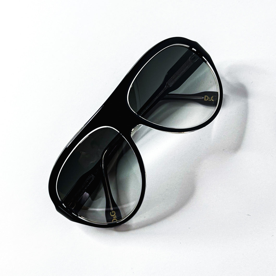 Lunettes de soleil D&G noires avec verres dégradés, vue de dessus.