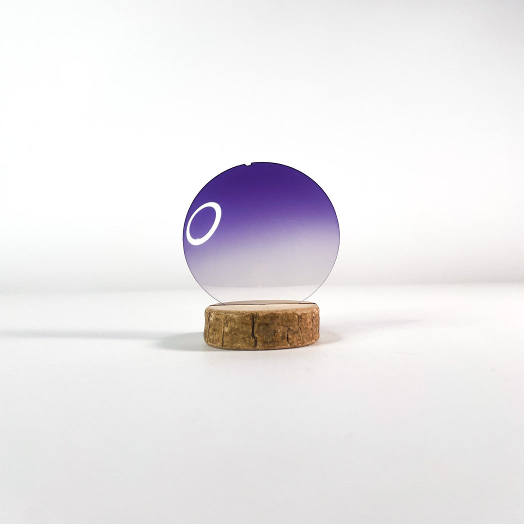 Verre de lunettes de soleil violet bidégradé  sur un support avec fond blanc