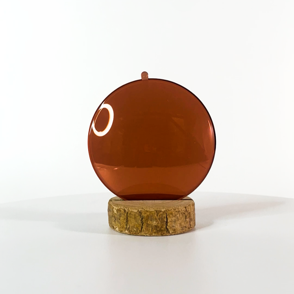 Verre de lunettes de soleil brun polarisé sur un fond blanc et socle en bois