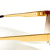 Vue rapprochée des détails métalliques dorés sur lunettes Missoni M 187/S