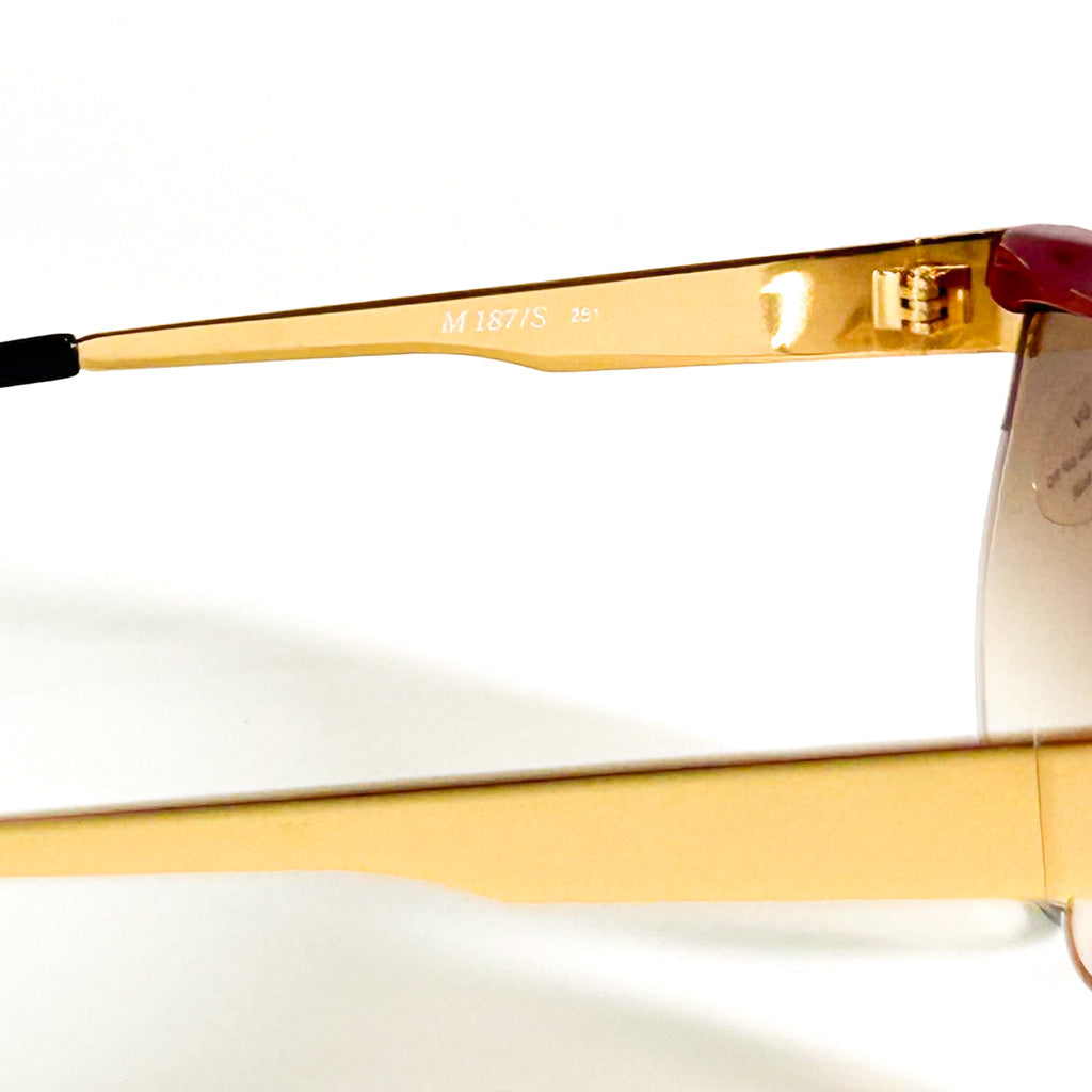 Vue rapprochée des détails métalliques dorés sur lunettes Missoni M 187/S