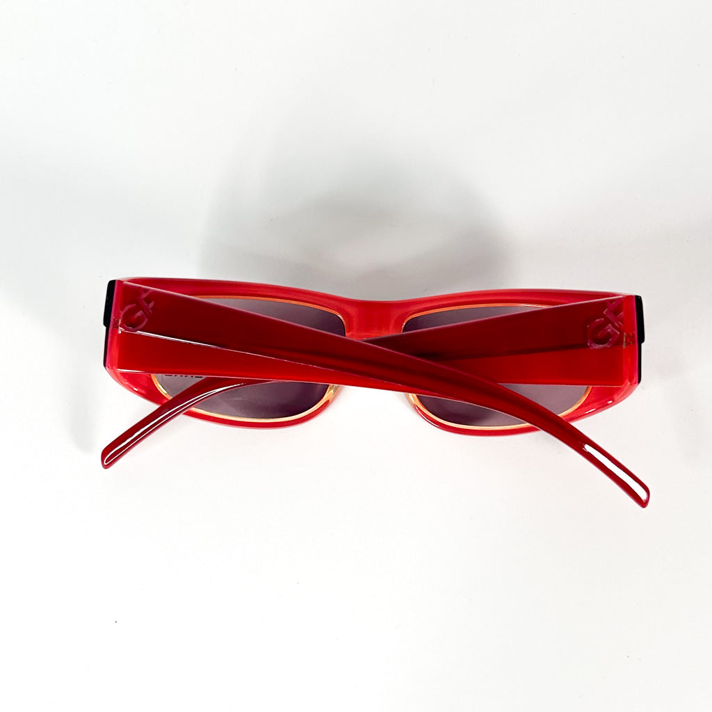 Vue de dessus des lunettes de soleil Gianfranco Ferré rouges, avec branches croisées