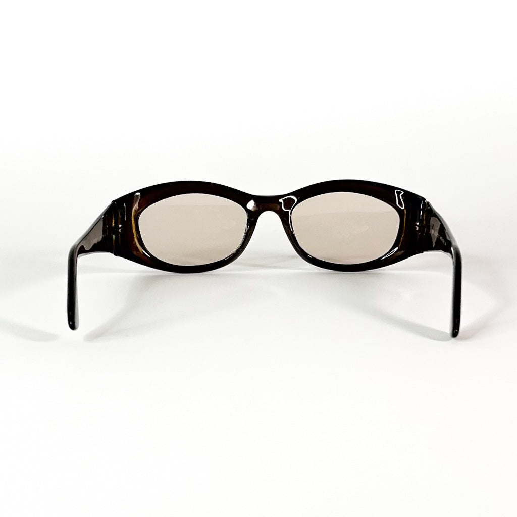 Gros plan sur le logo Gucci argenté sur la branche droite d’une paire de lunettes vintage