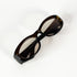 Détail du logo Gucci argenté sur la branche gauche d’une paire de lunettes vintage