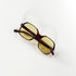 Lunettes de soleil vintage Jean Lempereur 114, modèle écaille aux verres jaunes, posées face vers le bas