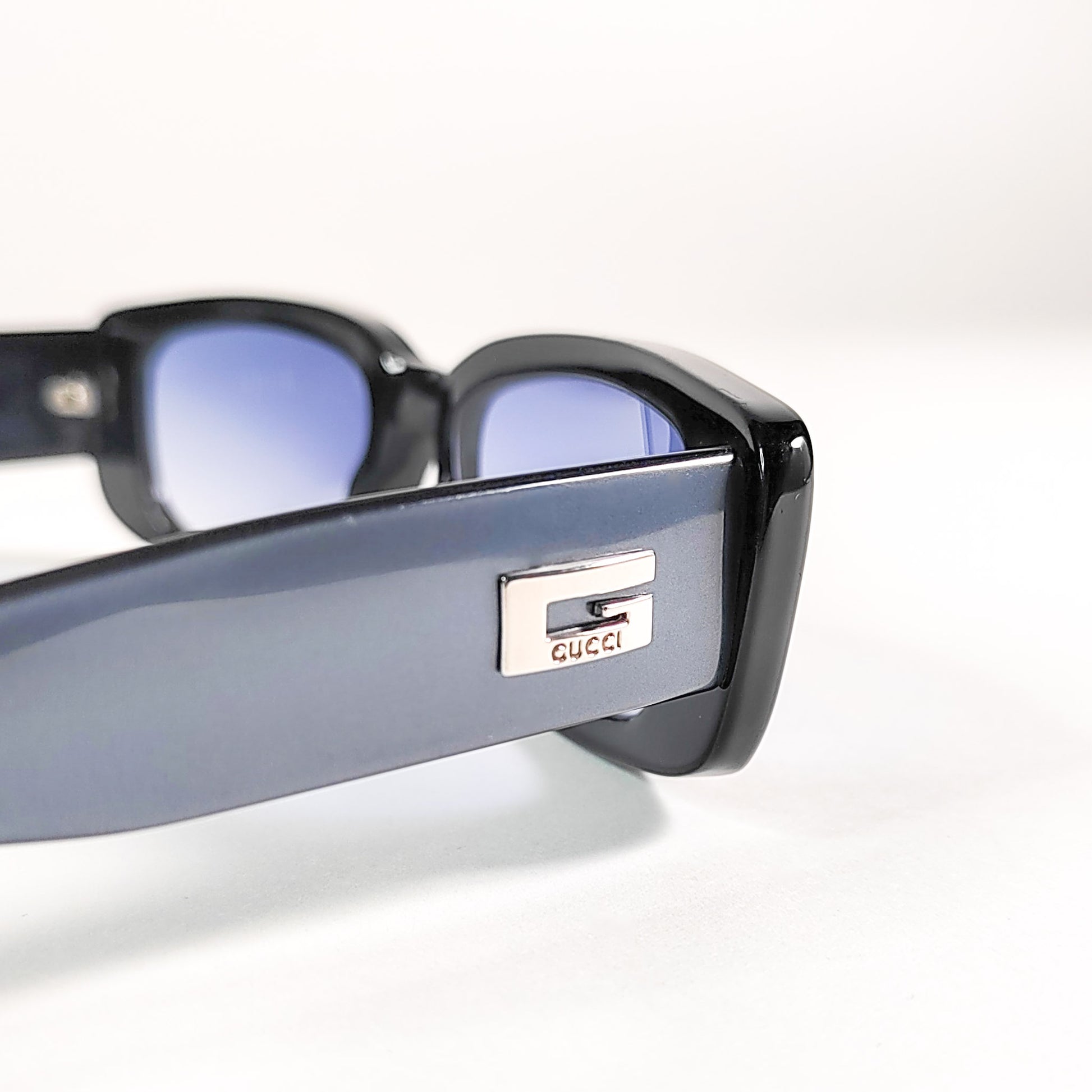Gucci GG 2409/N/S, gros plan sur la plaque métal argentée G Gucci appliquée sur la branche extérieure.