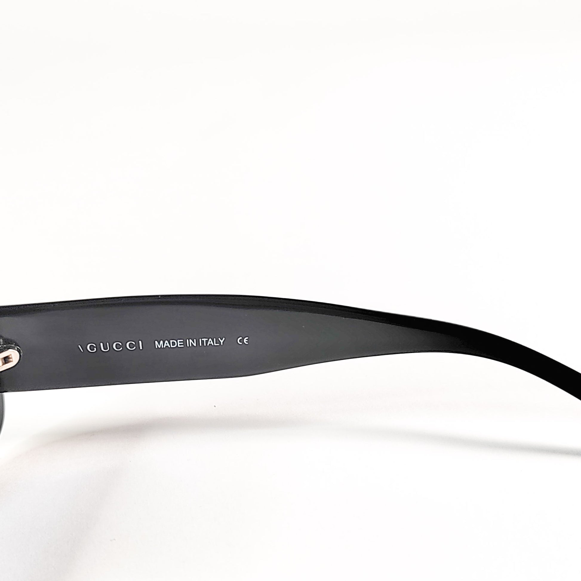 Gucci GG 2409/N/S, gros plan macro sur la signature GUCCI Made in Italy à l'intérieur de la branche.