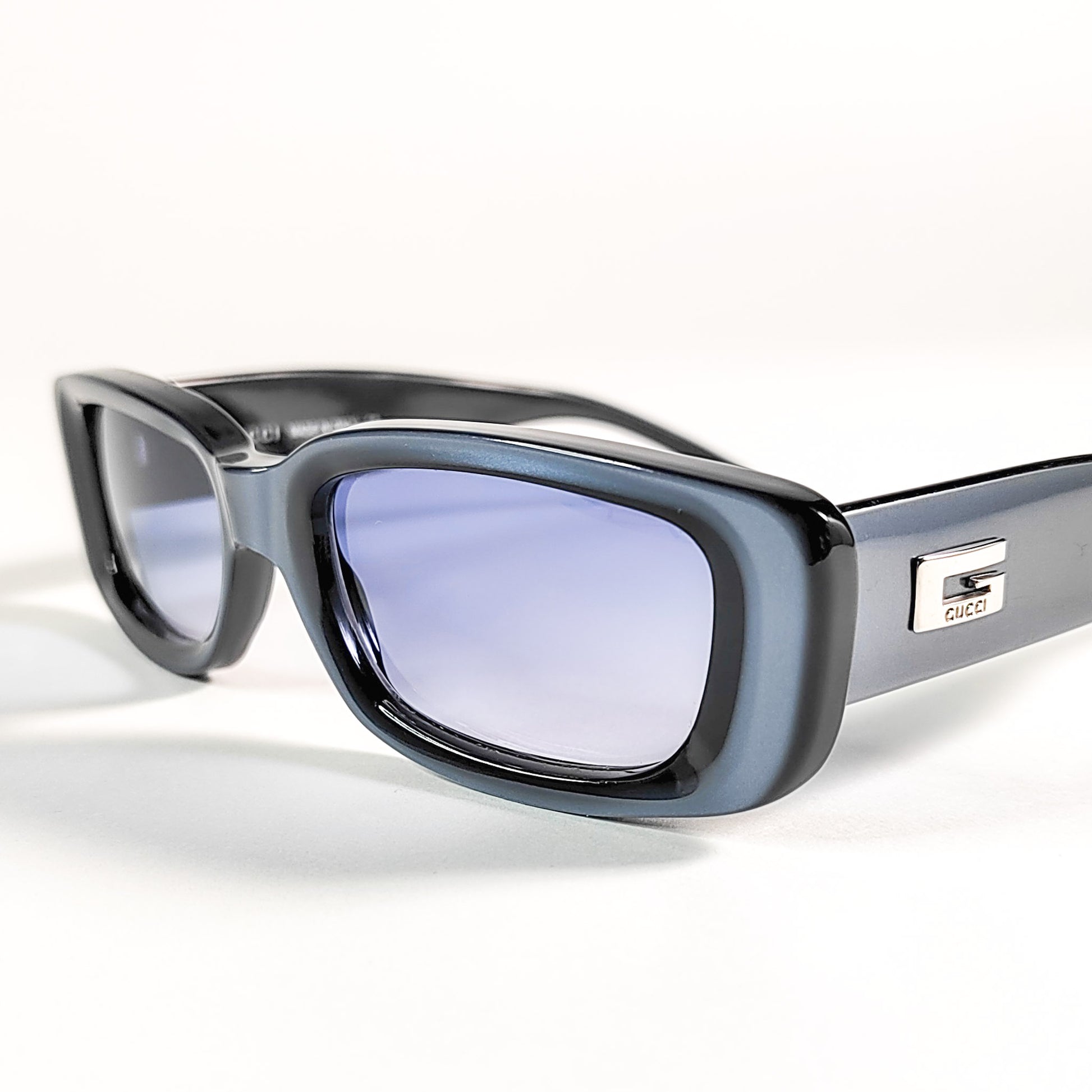 Gucci GG 2409/N/S, vue 3/4 avant montrant la plaque métal G Gucci sur la branche et les verres bleu poudré.