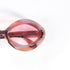 Gros plan sur la signature Sevima gravée à l'intérieur de la branche en acétate rose des lunettes vintage