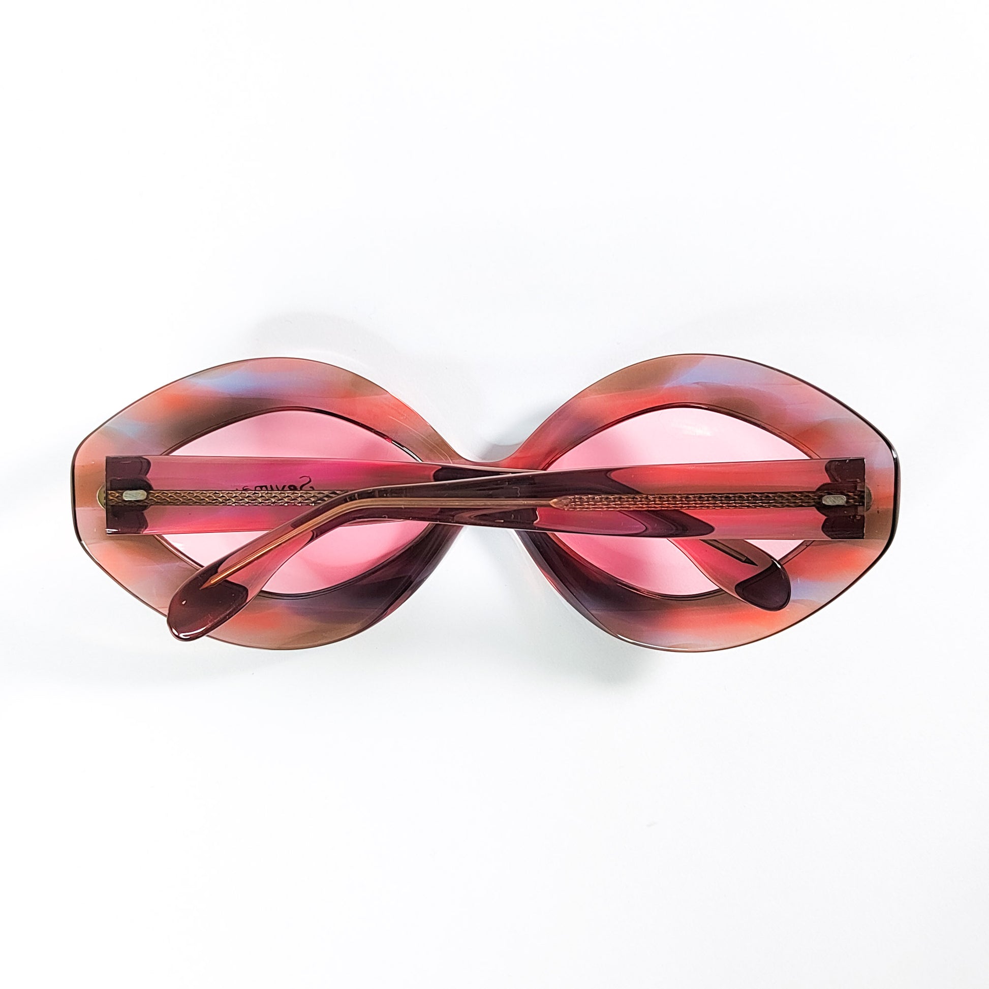 Vue de dessus des lunettes de soleil Sevima vintage branches pliées, acétate marbré rose et brun années 60