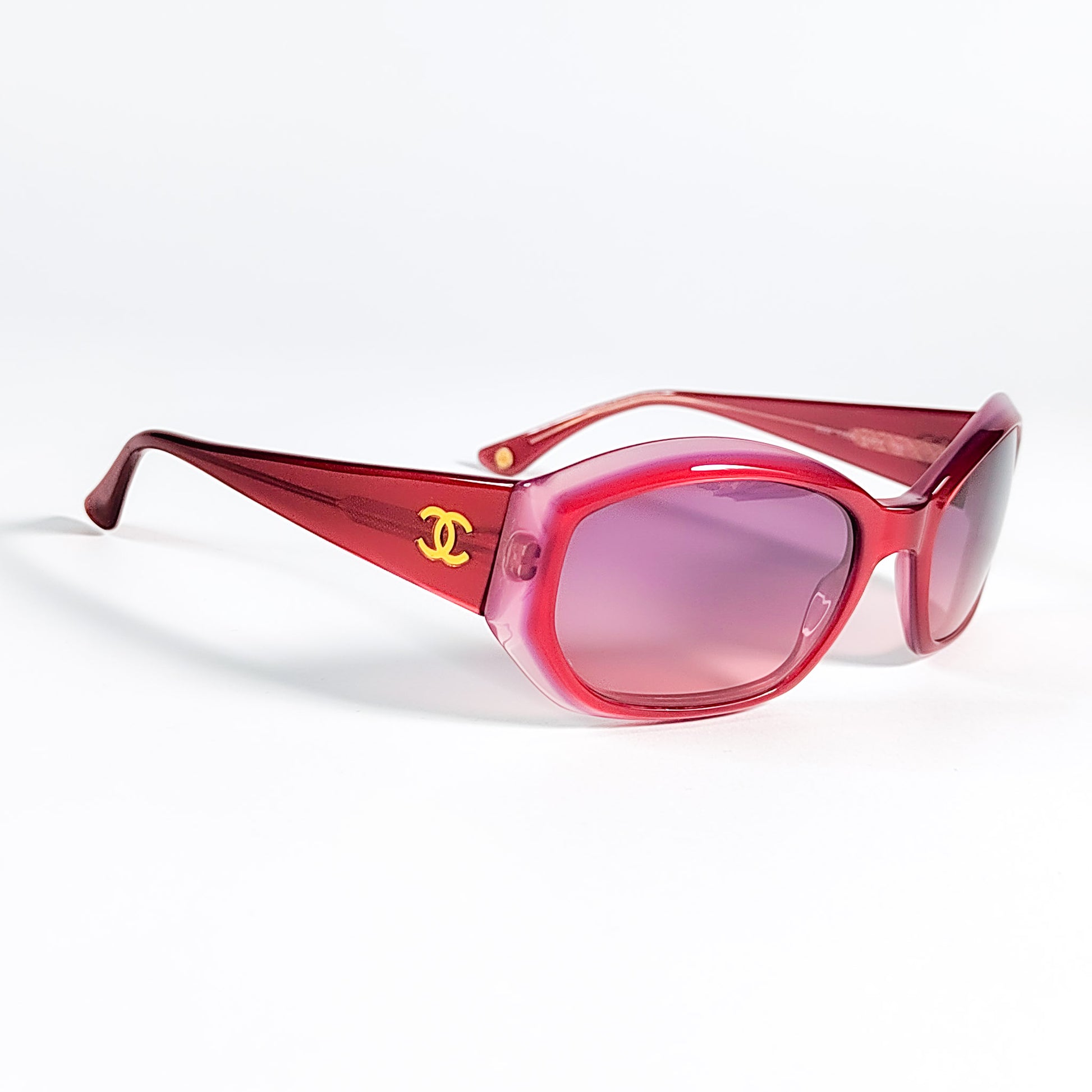 Vue 3/4 face lunettes Chanel 5022 c.600, acétate rouge framboise translucide et verres rose dégradé, logo CC doré visible